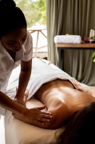 a woman is performing acupuncture on a mans stomach at Bufo Alvarius in Tulum