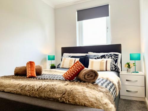 a bedroom with a bed with pillows on it at Luxurious & Modern Apartment in Hawkhead