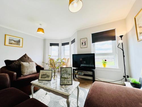 a living room with a couch and a tv at Luxurious & Modern Apartment in Hawkhead