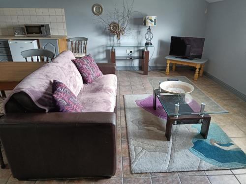 a living room with a couch and a table at Dingle Town Center Apartment in Dingle