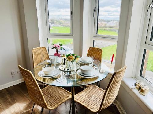 una sala da pranzo con tavolo in vetro e sedie di Luxurious & Modern Apartment a Hawkhead