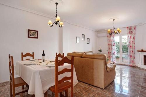 a dining room with a table and a couch at Aptº ATALAYA , cerca de la Playa in Conil de la Frontera
