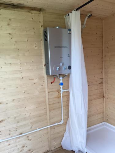 a room with a boiler and a curtain at Vigo Retreat Yurt in Wrotham