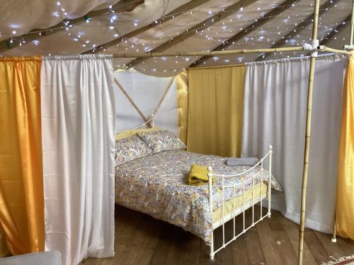 1 dormitorio con cama con dosel en una tienda de campaña en Vigo Retreat Yurt, en Wrotham