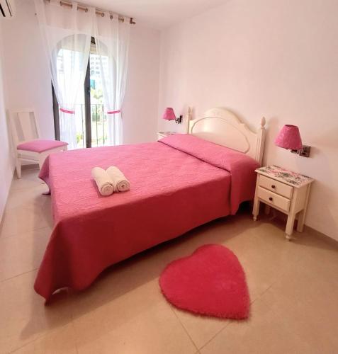 a bedroom with a red bed with two towels on it at Lookatbeach in Oropesa del Mar