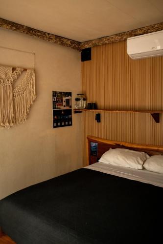 a bedroom with a bed with a black comforter at Bufo Alvarius in Tulum