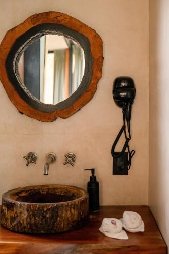 a bathroom sink with a large mirror on the wall at Bufo Alvarius in Tulum