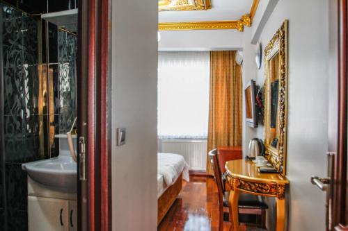 een slaapkamer met een bed, een tafel en een wastafel bij Californiacityhotel in Istanbul