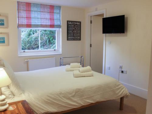 a bedroom with a bed with two towels on it at 13 Combehaven in Salcombe