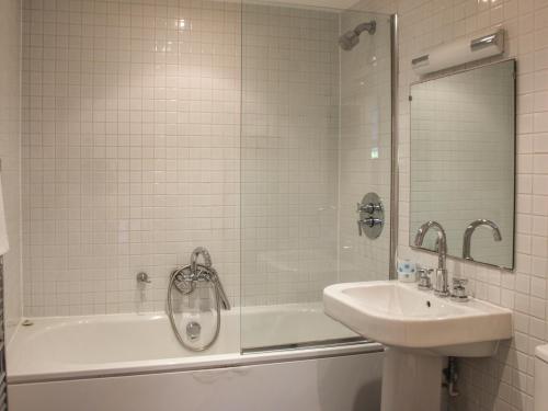 a bathroom with a tub and a sink and a mirror at 13 Combehaven in Salcombe