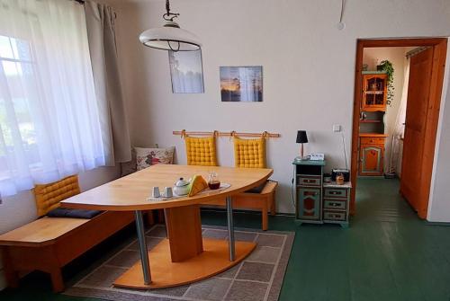 Habitación con mesa de madera, sillas, mesa y mesa de mesa. en Gemütlichkeit am Vierkanthof - Apartment 2, en Wörterberg