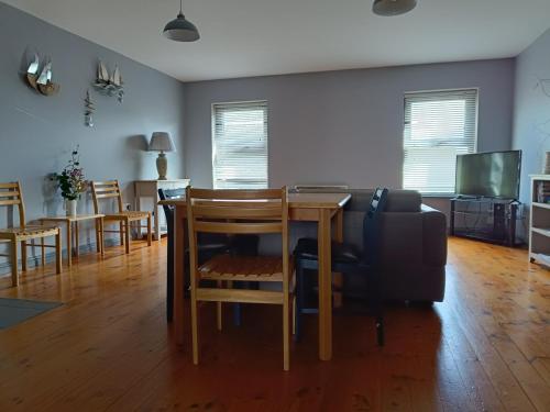 a living room with a table and chairs and a couch at Dingle Town Center Apartment in Dingle