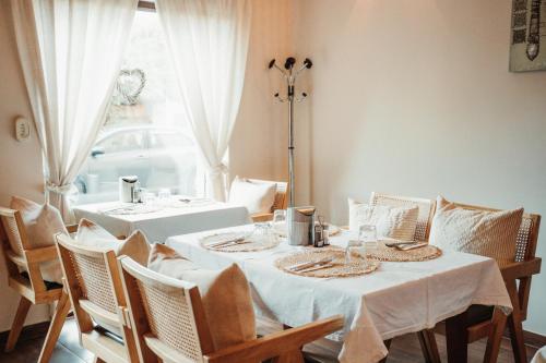 a dining room with two tables and chairs and a window at Hotel La Riva in Siófok