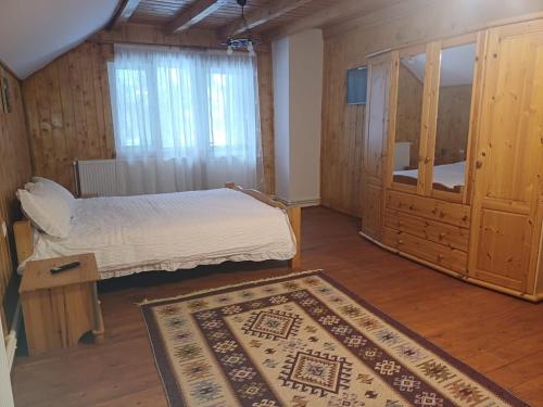 een slaapkamer met een bed en een tapijt op de vloer bij Sătic Casa Maria in Sătic