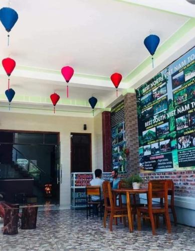 dos personas sentadas en una mesa en un restaurante con globos en Nana Lee Homestay Phong Nha en Cừ Lạc