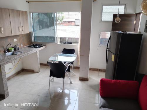 a kitchen with a small table and a refrigerator at Alojamiento y transporte in Guayaquil