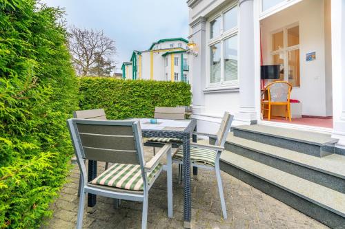 a table and chairs on the front porch of a house at Pension Wald und See in Ahlbeck
