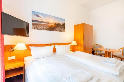アールベックにあるPension Wald und Seeのベッド2台、薄型テレビが備わるホテルルームです。