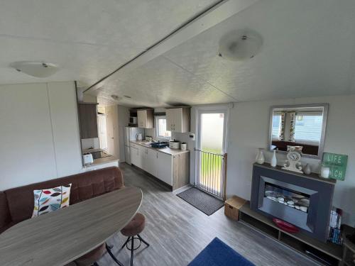 a living room with a couch and a fireplace at Ormesby 8, Haven Holiday Park, Caister - Four Bedroom, sleeps 8, pets welcome - 2 minutes from the beach! Entertainment passes required in Great Yarmouth