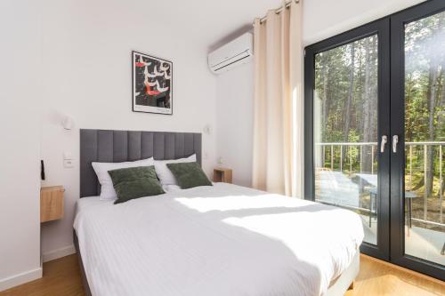 a bedroom with a large bed and a large window at uTadka in Sztutowo