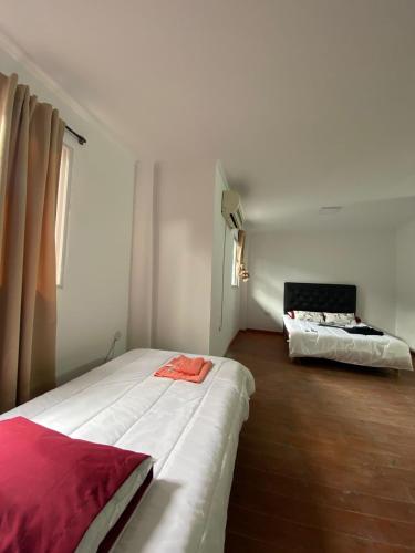 Habitación blanca con 2 camas y ventana en Work And Home en Cañuelas