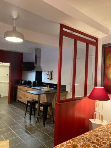 uma cozinha com mesa e cadeiras num quarto em L’Atelier cosy em Auxerre
