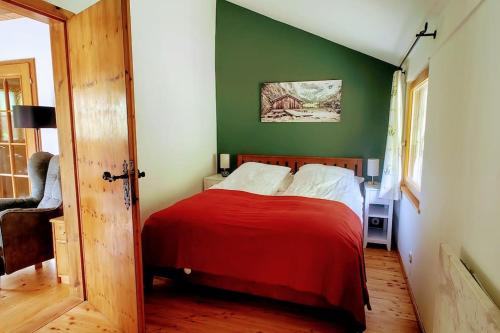 a bedroom with a red bed with a green wall at Wald & Bach Gutenstein (50 Minuten von Wien) in Gutenstein