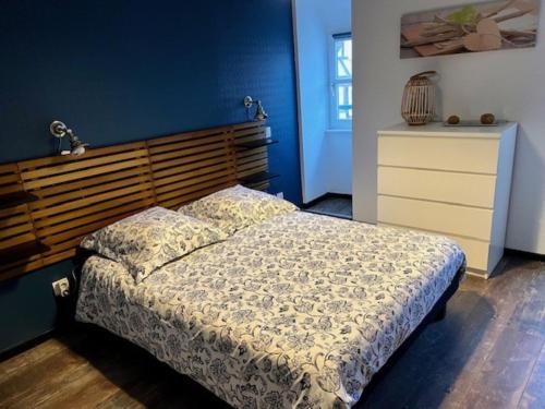 a bedroom with a bed with a wooden headboard and a dresser at Gîte Grand'Rue "Climatisé" in Colmar