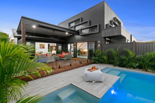 a house with a swimming pool in front of it at Modern Luxury Pool Oasis in Buddina