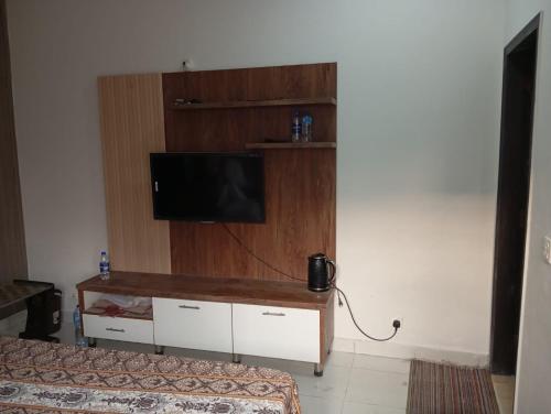 sala de estar con TV en la pared en Balqees Cottage, en Lahore