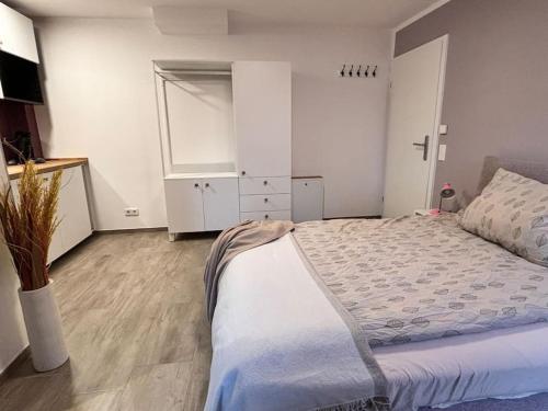 a bedroom with a large bed and a white cabinet at Gemütlich mitten in Neu-Isenburg in Neu Isenburg