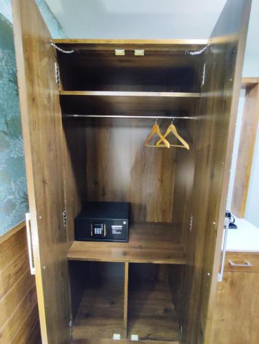 a wooden cabinet with a stove in a room at Hotel GRT Square in Dhārwād
