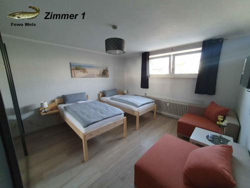 a small room with two beds and a couch at Fewo Helmstedt in Helmstedt