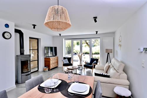 Una sala de estar con un sofá, una mesa y sillas. en Chez Laure - Gîte 4 personnes, près de Durbuy, en Durbuy