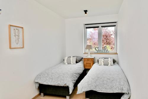 um quarto com 2 camas e uma janela em Chez Laure - Gîte 4-5 personnes, à 2 minutes de Durbuy em Durbuy