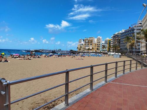 einen Strand mit Menschen, die auf Sand und Meer liegen in der Unterkunft MAND CANTERAS in Las Palmas de Gran Canaria
