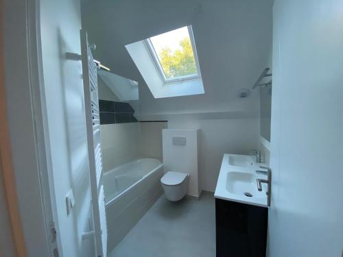 a bathroom with a sink and a toilet and a window at Appartement 10 personnes JO 2024 in Élancourt