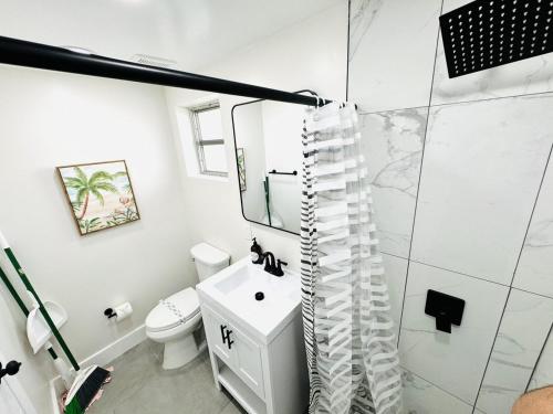 a white bathroom with a shower and a sink at Progresso Apts by Lowkl in Fort Lauderdale