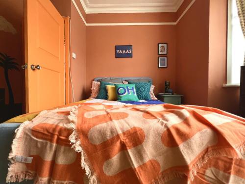a bedroom with a bed with an orange at Vibrant City Cottage in Camberwell in London