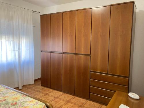 duża drewniana szafka w pokoju z łóżkiem w obiekcie Casa Assunta w mieście Donoratico