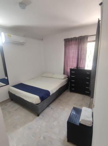 a small bedroom with a bed and a window at Cabaña Gaia Rodadero in Santa Marta