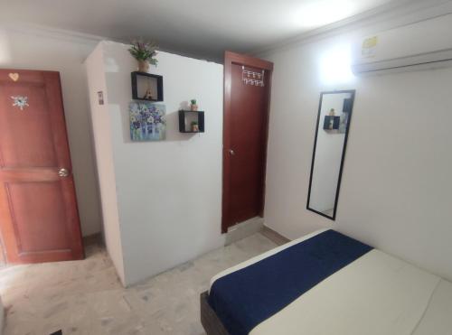 a bedroom with a bed and a red door at Cabaña Gaia Rodadero in Santa Marta