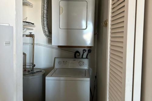 a small kitchen with a white stove and a washer at Sea Breeze Beach View in Seaside Heights