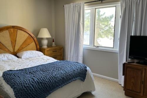 1 dormitorio con cama, ventana y TV en Sea Breeze Beach View, en Seaside Heights