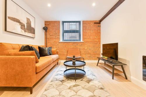 a living room with a couch and a brick wall at Lovely 2 Bed Apartment in Burton-on-Trent in Burton upon Trent
