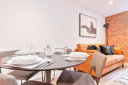 a dining room with a table and a couch at Lovely 2 Bed Apartment in Burton-on-Trent in Burton upon Trent
