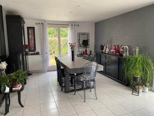 une cuisine avec une table et des chaises dans une pièce dans l'établissement Maison plein pied proche circuit 24h et PEC, à Yvré-lʼÉvêque