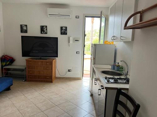 uma cozinha com um frigorífico e uma televisão na parede em Amerigo Casa Vacanza em Cefalù