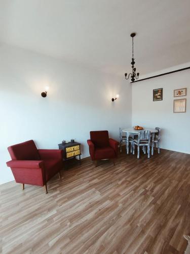 una sala de estar con 2 sillas rojas y una mesa. en Great apartment, en Figueira da Foz