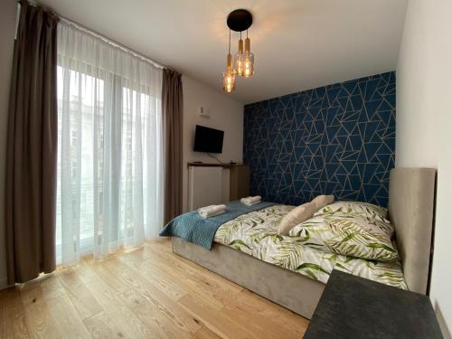 sypialnia z łóżkiem i niebieską ścianą w obiekcie Vistula Avenue Apartment Free Parking w Krakowie